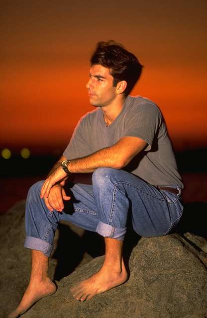 Joven descalzo, sentado al atardecer